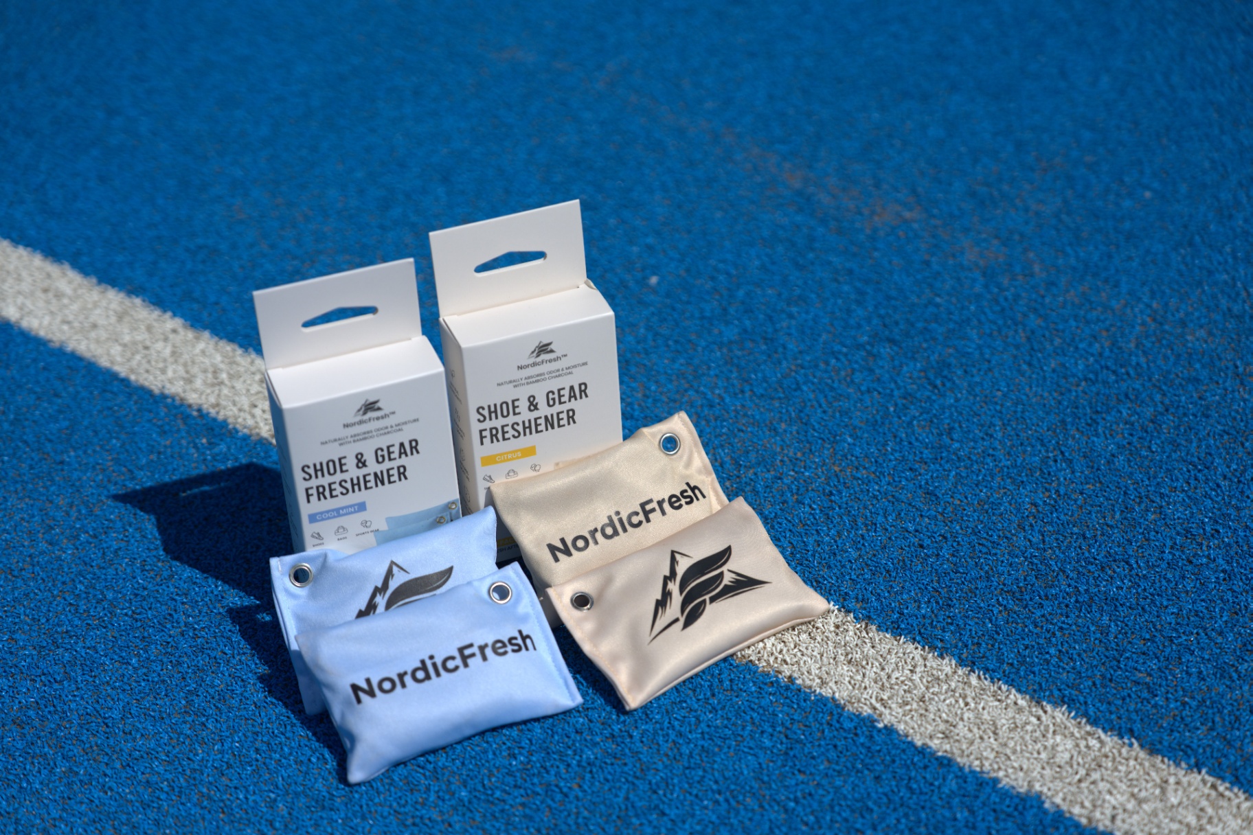 NordicFresh Cool Mint and Citrus shoe & gear fresheners on a blue padel court